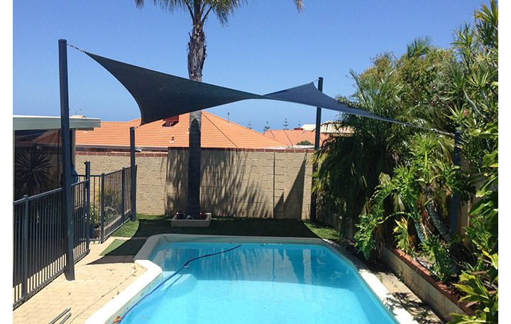 Photograph of Hyper Sail providing shade over pool. 4 posts, fabric is comshade navy blue.