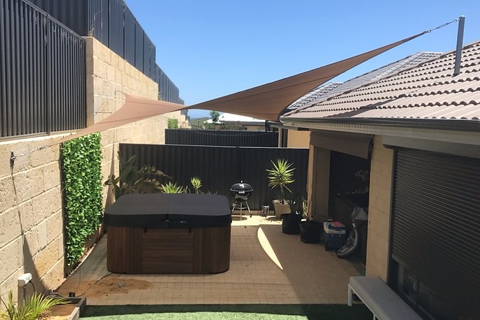 Photograph of Hypar Shade sail over customers new spa 
Rainbowshade Z16 Cinnamon 
2 x wall plates
1 x specially made and engineered corner bracket
1 x high roof mast
.
