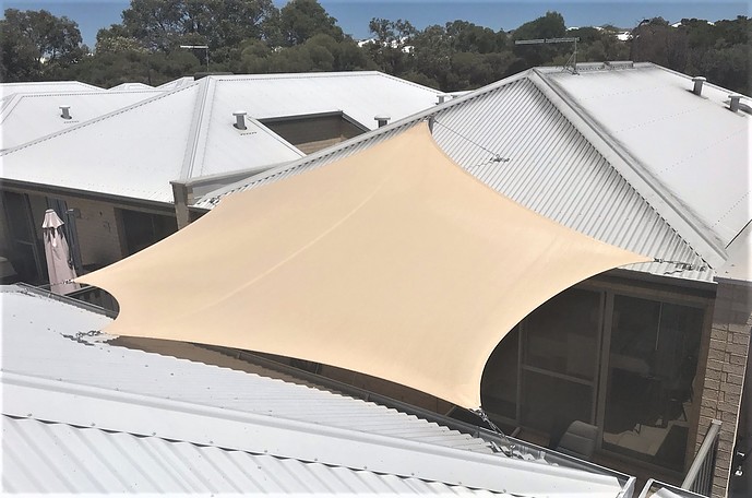Photograph of Shade sail between house and garage - cottage block
Rainbowshade Z16 Desert Sand 
5 x ripple plates
1 x high roof mast especially for Colorbond roofs
