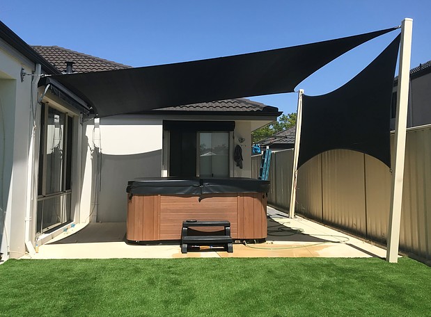 Photograph of Shade sail over customers spa as well as a privacy screen in rainbow Z16 Black
